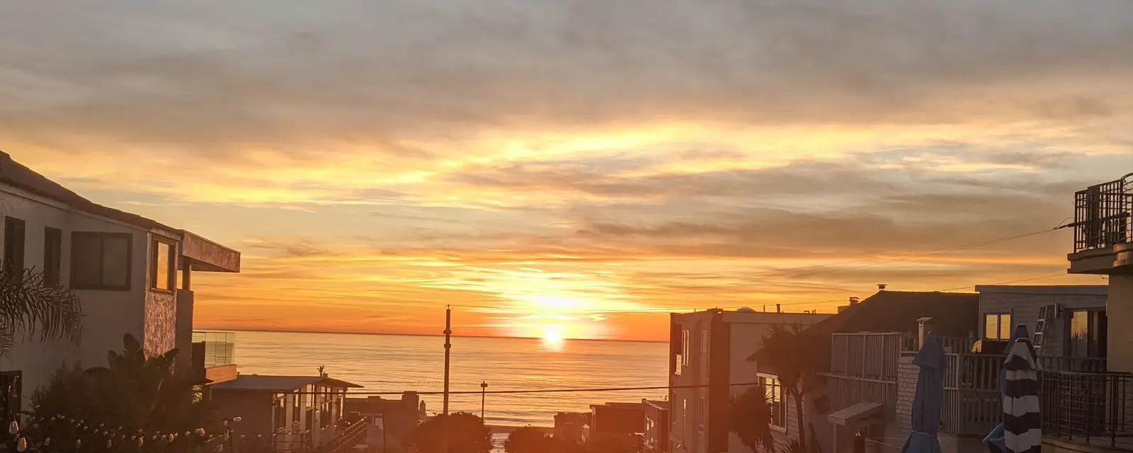 A walk street sloping down to the ocean at sunset