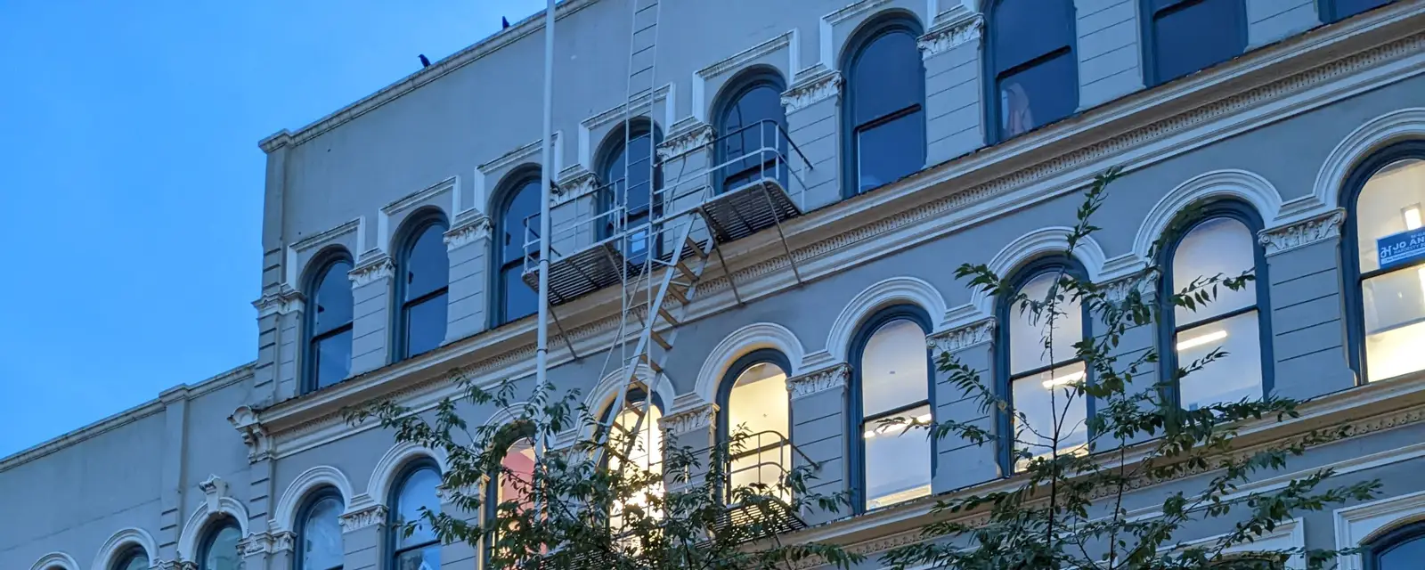 Warm windows on a historic brick block at dusk