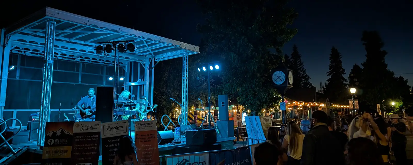 An outdoor evening concert with a small crowd