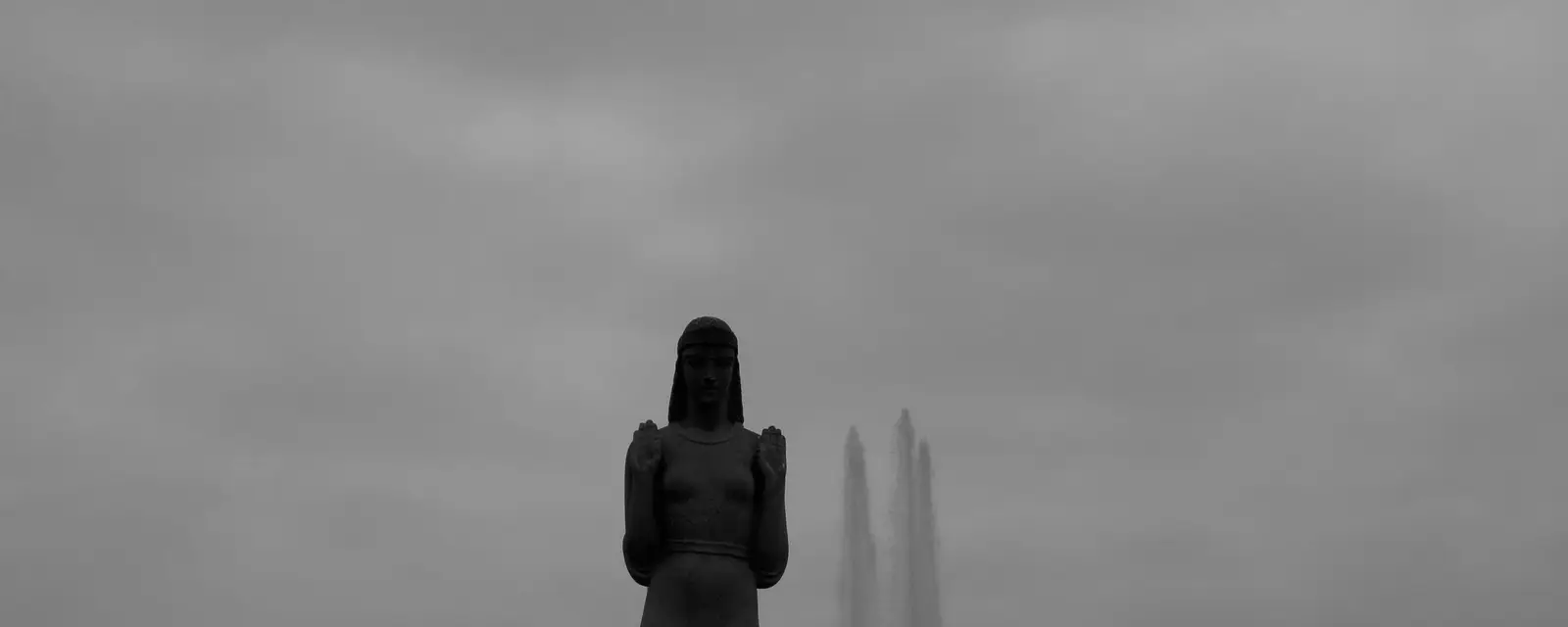 A quiet park lake with fountains on an overcast day